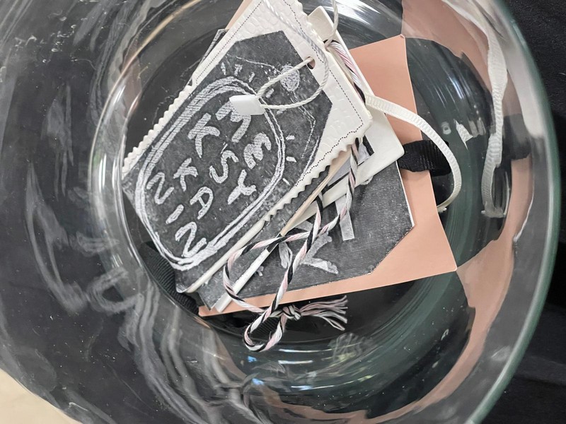 Szklany pojemnik w nim metki z zapisanymi róznymi narodowościami na pierwszym tle metka z napisem meksykanin